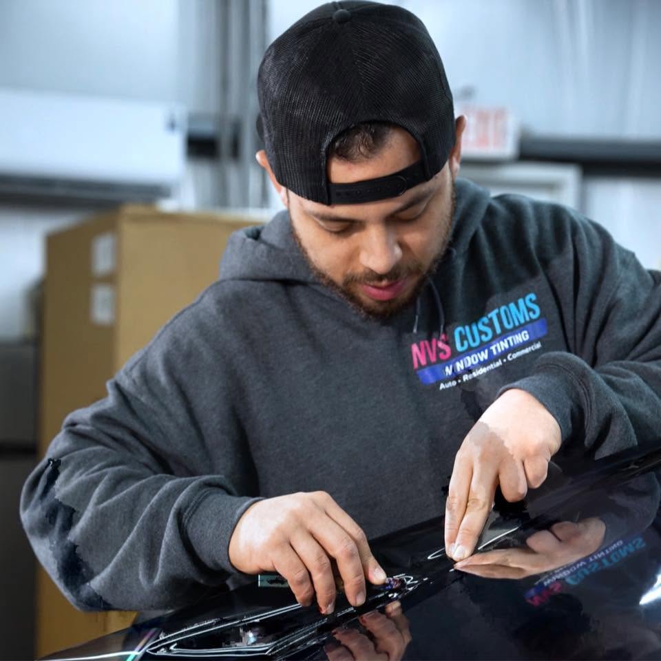 NVS Customs installer applying auto window tint film in the shop, Wilmington, NC.